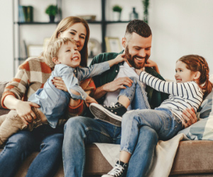 Happy family hugging and playing together on couch, in Nashville Tennessee.